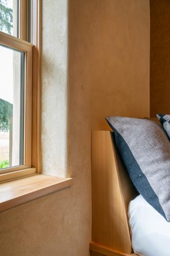 straw bale wall highlight window with pillow and twin bed